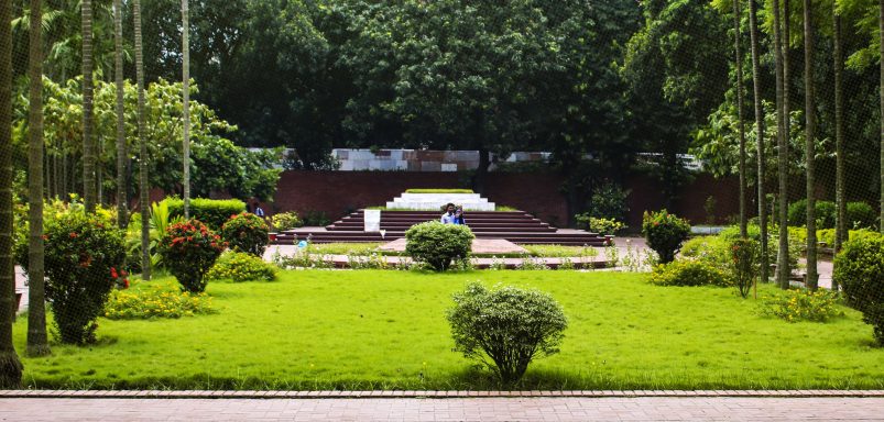 Who are the notable figures buried beside Nazrul Islam and Sharif Osman Hadi?
