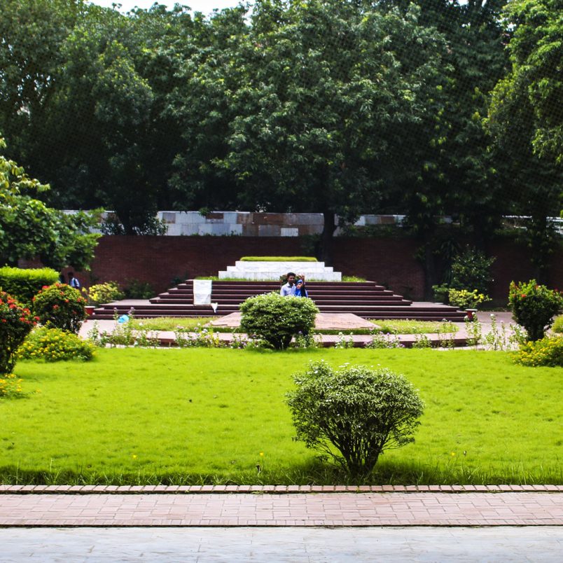 Who are the notable figures buried beside Nazrul Islam and Sharif Osman Hadi?
